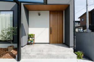 木目の軒天と木製玄関ドアであたたかみを感じる玄関ポーチ