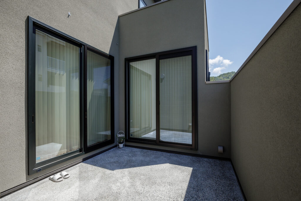 建物や壁に囲まれたプライベートな中庭のある家